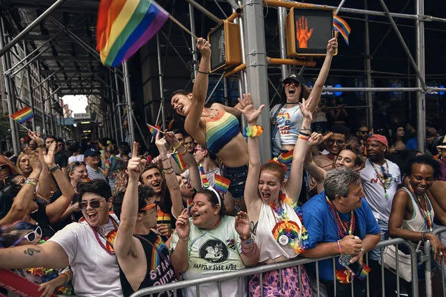 People cheer as floats travel along Fifth Avenue during the New York City Pride Parade on Sunday, June 25, 2017, in New York. (Photo by Andres Kudacki/AP Photo)
