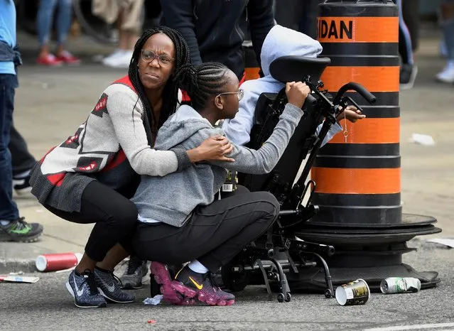 People take cover after reports of shots fired in the area where crowds gathered in Nathan Phillips Square to celebrate the Toronto Raptors victory parade in Toronto, Ontario, Canada on June 17, 2019. (Photo by Moe Doiron/Reuters)