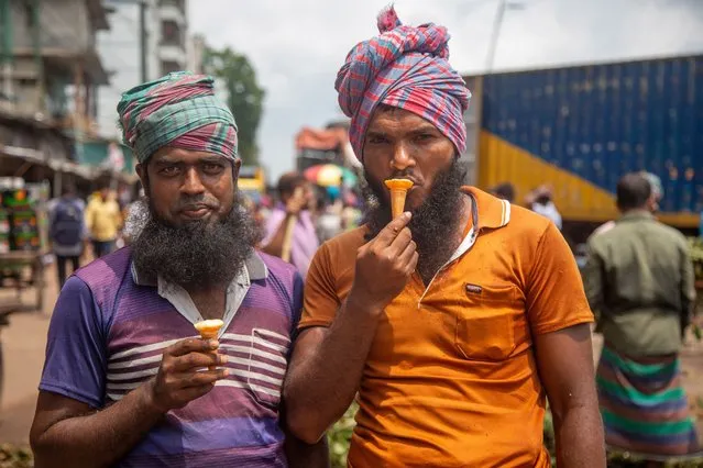 Day laborers eat ice-cream during a hot summer day in Dhaka, Bangladesh, 17 May 2022. According to the Bangladesh Meteorological Departmen​t (MET) office report, a mild heat wave sweeping over Bangladesh. (Photo by Monirul Alam/EPA/EFE)