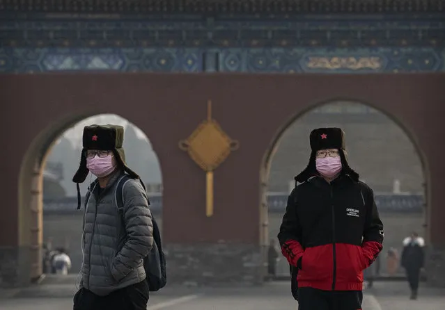 Chinese visitors wear protective masks as they tour the grounds of the Temple of Heaven, which remained open during the Chinese New Year and Spring Festival holiday on January 27, 2020 in Beijing, China. (Photo by Kevin Frayer/Getty Images)