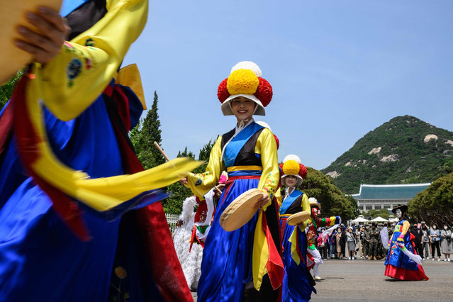 Performers dance near the Blue House compound, a day after it was opened to the public following a campaign promise by President Yoon Suk-yeol, in Seoul on May 11, 2022. (Photo by Anthony Wallace/AFP Photo)