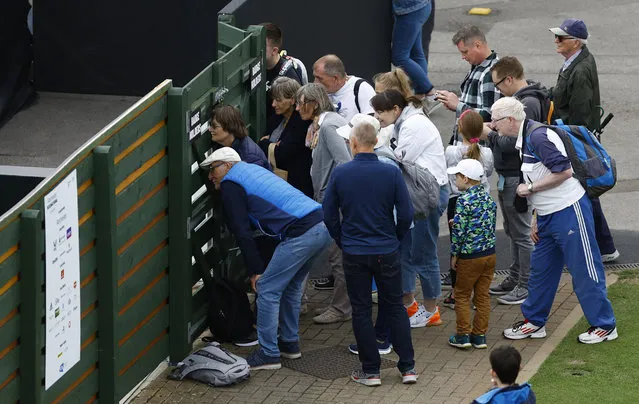 Fans look through the fence during the qualifying match of the Eastbourne international tennis tournament between Britain's Heather Watson and Ukraine's Lesia Tsurenko in Eastbourne, Britain on June 19, 2022. (Photo by Andrew Boyers/Action Images via Reuters)