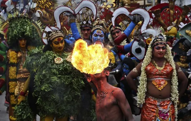 An artist performs with fire during a procession as part of “Bonalu” festivities in Hyderabad, India, on Jule 21, 2014. Bonalu is a Hindu folk festival of the Telangana State. (Photo by Mahesh Kumar A./Associated Press)