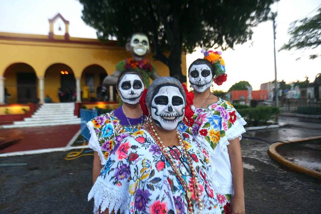 People with painted faces and clad in regional Mesrizo clothing take part in a procession representing The Walk of the Souls, which is the arrival of the spirits according to the Mayan worldview, as part of observances for the Day of the Dead in Merida, Mexico's Yucatan state on October 31, 2024. (Photo by Hugo Borges/AFP Photo)