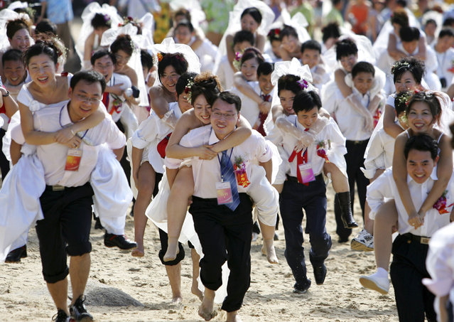 Grooms carrying their brides run during a mini marathon celebrating the New Year in Sanya, south China's Hainan province, January 2, 2007. (Photo by Andy Gao/Reuters)
