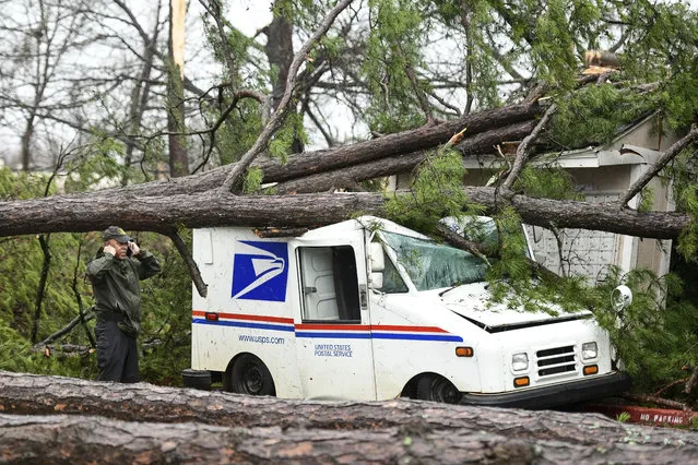 A man talks on the phone next to a damaged postal truck at an apartment complex where a reported tornado passed through Thursday, February 6, 2020, in Spartanburg, S.C. A powerful winter storm brought severe weather across the Deep South early Thursday, with high winds causing damage that killed one person, injured several others and littered at least four states. (Photo by Sean Rayford/AP Photo)