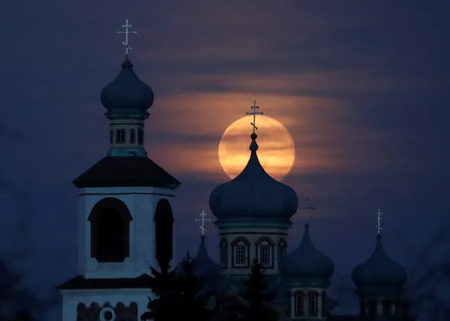 Full moon rises behind an Orthodox Church in the village of Turets, on Belarus February 9, 2020. (Photo by Vasily Fedosenko/Reuters)