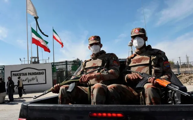 Pakistani soldiers wearing facemasks patrol near the closed Pakistan-Iran border in Taftan on February 25, 2020 as fears over the spread of the COVID-19 coronavirus escalate following an outbreak in neighbouring Iran. The Iranian outbreak where at least 15 people have already died – the highest death toll in any country outside of China – has aggravated already frayed nerves in neighbouring Afghanistan and Pakistan. (Photo by Banaras Khan/AFP Photo)