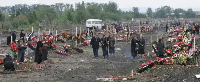 The relatives of the victims of the hostage crisis mourn at the graves on the new territory of the local cemetery on the third day of the funerals in Beslan, North Ossetia, Tuesday 07 September 2004. 335 people died in a hostage taking drama. (Photo by Sergei Chirikov/EPA)