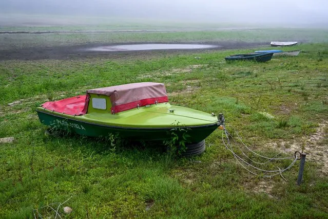 A boat sits on the exposed bottom of one of the arms of the Solinskie (Solina) Lake, in the town of Chrewt, southeastern Poland, 30 August 2022. Due to the lack of rainfall and the drought, the water level in the lake is constantly decreasing. (Photo by Darek Delmanowicz/EPA/EFE)