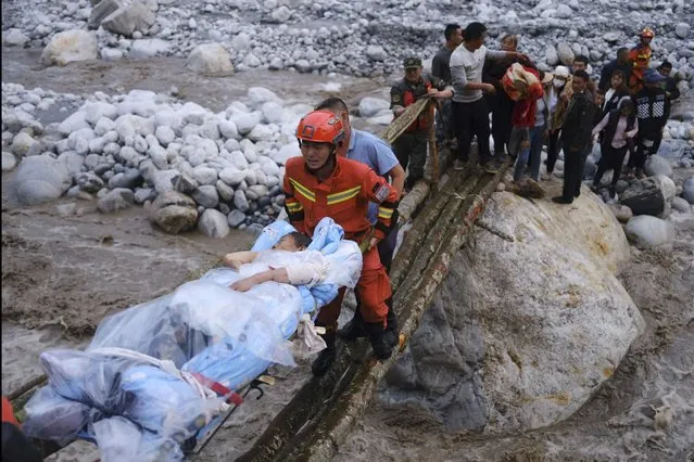 In this photo released by Xinhua News Agency, rescuers transfer survivors across a river following an earthquake in Moxi Town of Luding County, southwest China's Sichuan Province on Monday, September 5, 2022. Dozens people were reported killed and missing in a 6.8 magnitude earthquake that shook China's southwestern province of Sichuan on Monday, triggering landslides and shaking buildings in the provincial capital of Chengdu, whose 21 million residents are already under a COVID-19 lockdown. (Photo by Cheng Xueli/Xinhua via AP Photo)
