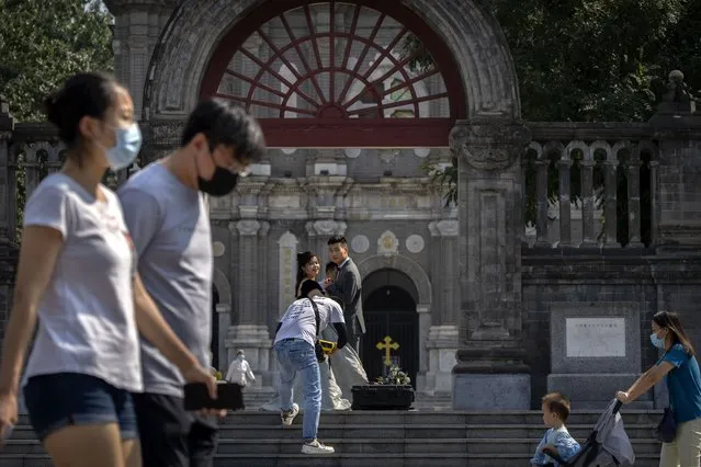 A couple poses for photos on the steps of the Wangfujing Church, a Catholic church in Beijing, Wednesday, September 14, 2022. (Photo by Mark Schiefelbein/AP Photo)