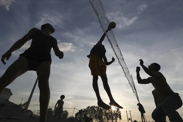 Local construction workers are silhouetted as they play volleyball after work near a construction site at Prey Mou village outside Phnom Penh, Cambodia, Thursday, January 2, 2020. (Photo by Heng Sinith/AP Photo)