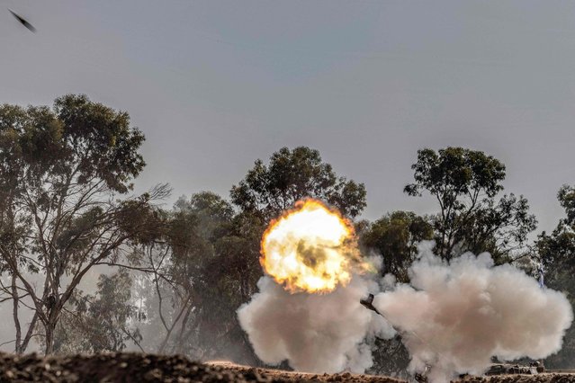 An Israeli army self-propelled artillery howitzer fires rounds from a position near the border with the Gaza Strip in southern Israel on November 6, 2023 amid the ongoing battles between Israel and the Palestinian group Hamas in the Gaza Strip. (Photo by Menahem Kahana/AFP Photo)