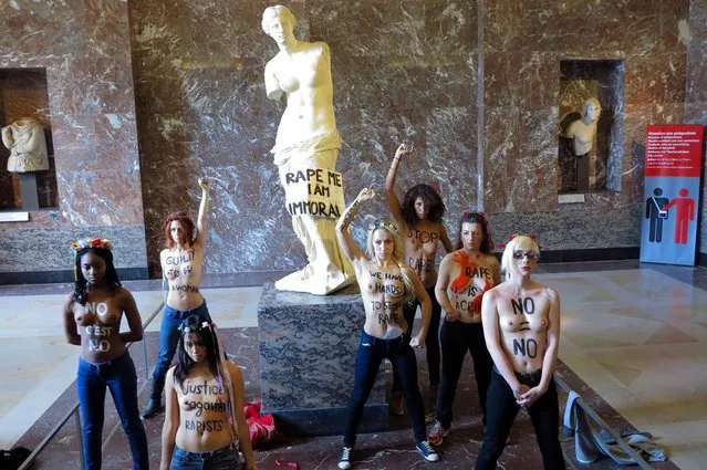 Topless activists of the Ukrainian women movement Femen protest against anti women's politic in front of the Venus de Milo statue where they hung a banner, at the Louvre Museum on October 3, 2012 in Paris. AFP PHOTO LIONEL BONAVENTURE (Photo credit should read LIONEL BONAVENTURE/AFP)