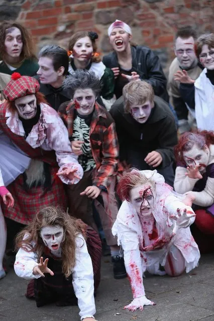 Zombie enthusiasts rehearse a dance before setting out on a “Zombie Walk” in the city center on October 27, 2012 in Berlin, Germany. Approximately 150 zombies, who had organized themselves through Facebook, walked and limped across Alexanderplatz, growled and moaned at passersby and performed jerking dances. (Photo by Sean Gallup)