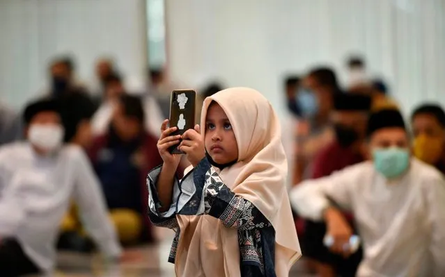 A child takes a photograph during a wedding ceremony at a mosque in Banda Aceh on June 3, 2020. (Photo by Chaideer Mahyuddin/AFP Photo)