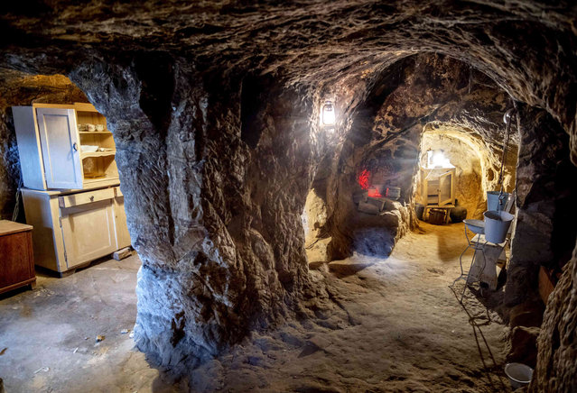The inside of a cave dwelling is pictured in Langenstein, eastern Germany, Tuesday, January 2, 2024. Workers of a nearby sheep farm built twelve of these caves in the rocks where they lived with their families from 1858 to 1910. (Photo by Michael Probst/AP Photo)