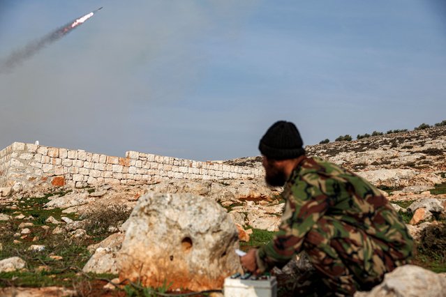 A Syrian fighter affiliated with the Hayat Tahrir al-Sham (HTS) group operates the remote for a pickup-mounted rocket launcher firing at Syrian government forces' positions in the northwest of Aleppo province on January 1, 2024. (Photo by Omar Haj Kadour/AFP Photo)