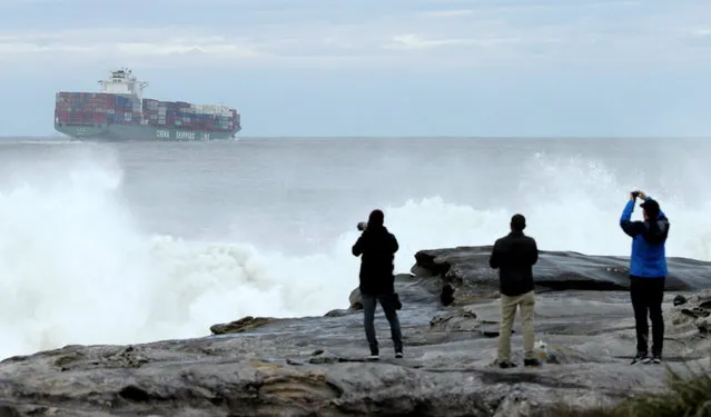 A China Shipping Line container ship sails out from Sydney's Botany Bay port as photographers take pictures of a surfing contest in heavy seas near Australia's largest city, June 6, 2016. (Photo by Jason Reed/Reuters)