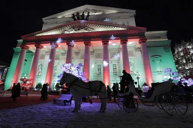 A horse drawn carriage is seen during a costume show, as a part of the upcoming New Year and Christmas celebrations, in front of the Bolshoi Theatre in Moscow, Russia December 24, 2017. (Photo by Tatyana Makeyeva/Reuters)