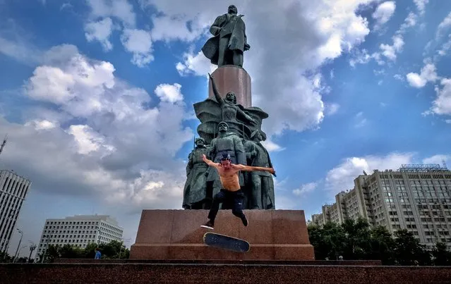 A skateboarder performs a trick in front of a monument to the Soviet Union founder Vladimir Lenin in Moscow on July 27, 2020. (Photo by Yuri Kadobnov/AFP Photo)