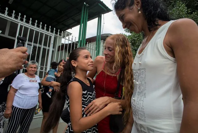 Laura Gil, center, stands with her mother Lisset Diaz Vallejo, center, outside the the notary office after her mother married her partner Liusba Grajales, right, in Santa Clara, Cuba, Friday, October 21, 2022. (Photo by Ismael Francisco/AP Photo)