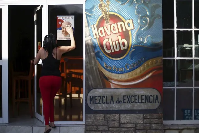 A woman cleans the window of a restaurant one day before the Pope Francis visit to Holguin, Cuba September 20, 2015. (Photo by Edgard Garrido/Reuters)