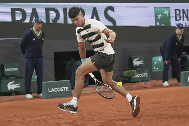 Spain's Carlos Alcaraz goes for a tweener shot as he plays Hungary's Fabian Maroszan during their second round match of the French Tennis Open, at the Roland-Garros stadium, in Paris, Wednesday, May 28, 2025. (Photo by Christophe Ena/AP Photo)