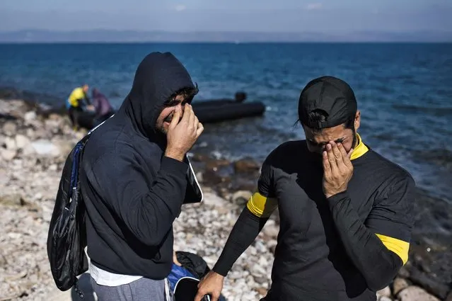 Two men cry as refugees and migrants arrive on the Greek island of Lesbos after crossing the Aegean sea from Turkey on October 9, 2015. Europe is grappling with its biggest migration challenge since World War II, with the main surge coming from civil war-torn Syria. (Photo by Dimitar Dilkoff/AFP Photo)