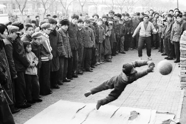 A boy and his father display their soccer skills on a roadside in Beijing in 1981. (Photo by Reuters/China Daily)