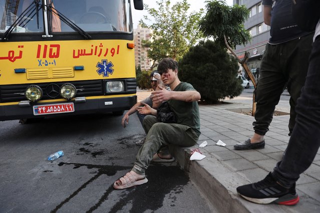 An injured person sits on a roadside in the aftermath of Israeli strikes, in Tehran, Iran, on June 13, 2025. (Photo by Majid Asgaripour/WANA News Agency via Reuters)