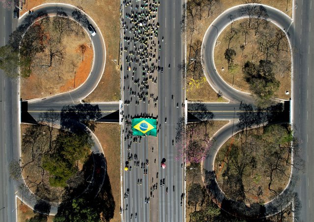 A drone view shows people gathering in support of former Brazilian President Jair Bolsonaro, after a court-ordered search of his house and political headquarters, and the imposition of an ankle monitor, in Brasilia, Brazil on July 20, 2025. (Photo by Adriano Machado/Reuters)