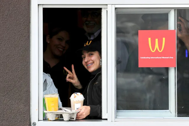 A worker works at drive through window as McDonald's iconic «M» logo is turned upside down in honour of International Women's Day in Lynwood, California, U.S., March 8, 2018. (Photo by Mike Blake/Reuters)