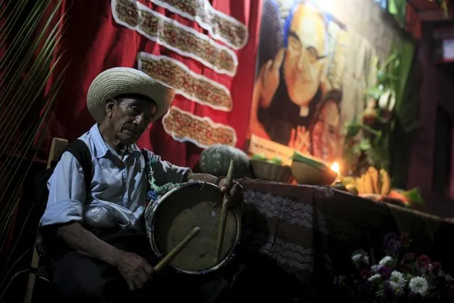 A man plays the drum at a family altar during the celebration of "Los Canchules" in Nahuizalcoams November 1, 2015. (Photo by Jose Cabezas/Reuters)