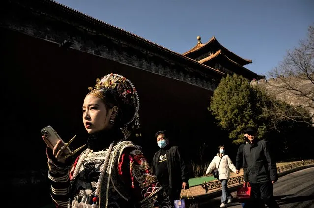 A woman wearing traditional clothes walks to the entrance of the Forbidden City in Beijing on March 1, 2023. (Photo by Noel Celis/AFP Photo)