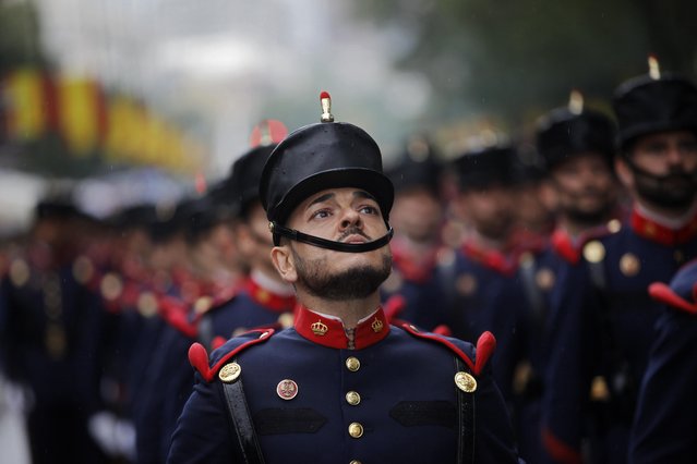 A Spanish soldier looks up as he marches with others in a military parade during a national holiday known as “Dia de la Hispanidad” or Hispanic Day, in Madrid, Spain, Wednesday, October 12, 2016. (Photo by Francisco Seco/AP Photo)