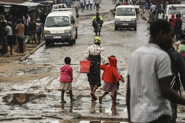 People walk down a flooded street following heavy rains caused by tropical Cyclone Freddy in Blantyre, southern Malawi, Wednesday, March 15, 2023. (Photo by Thoko Chikondi/AP Photo)