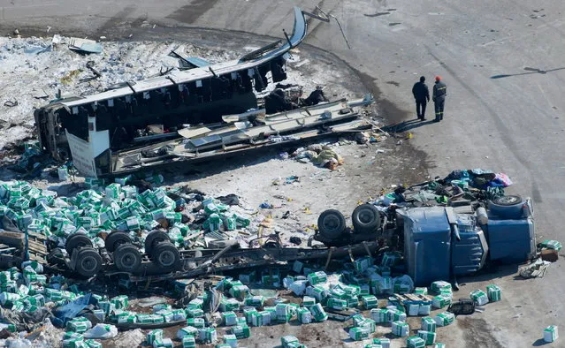 Emergency personnel work at the scene of a fatal crash outside of Tisdale, Saskatchewan, Canada, Saturday, April, 7, 2018. A bus, top, en route to Nipawin carrying the Humboldt Broncos junior hockey team crashed into a truck Friday night, killing 14 and sending over a dozen more to the hospital. (Photo by Jonathan Hayward/The Canadian Press via AP Photo)