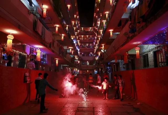 Children play with fire crackers while celebrating the Hindu festival of Diwali, the annual festival of lights in Mumbai, India, November 11, 2015. (Photo by Danish Siddiqui/Reuters)