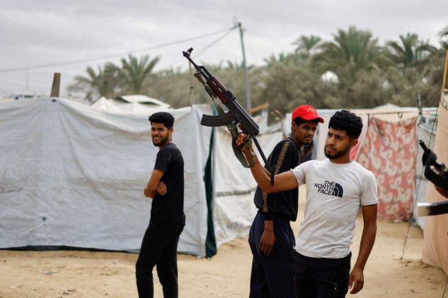 A Palestinian man points a weapon in the air after it was announced that Israel and Hamas agreed on the first phase of a Gaza ceasefire, in the central Gaza Strip, on October 9, 2025. (Photo by Mahmoud Issa/Reuters)