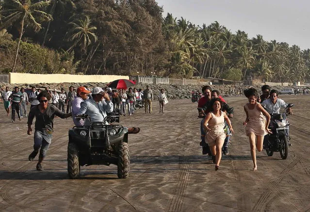 Bollywood actress Chitrashi Rawat (3rd R) runs along a beach, as she is chased, during the shoot for the film “Black Home” on the outskirts of Mumbai April 26, 2013. (Photo by Danish Siddiqui/Reuters)