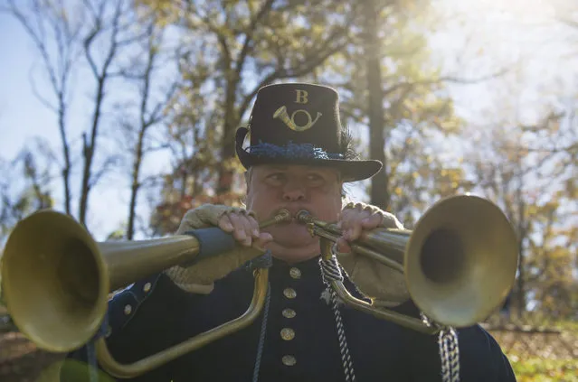 Chief bugler of the French Broad Army William Beard plays two bugles at once during the 152nd Fort Dickerson Civil War Weekend in Knoxville, Tenn., on Saturday, November 14, 2015. "This is a dumb bugle trick," Beard said. (Photo by Jessica Tezak/Knoxville News Sentinel via AP Photo)
