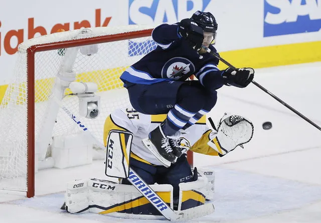Winnipeg Jets' Nikolaj Ehlers (27) attempts to deflect the puck past Nashville Predators goaltender Pekka Rinne (35) during the third period of Game 4 of an NHL hockey second-round playoff series in Winnipeg, Manitoba, Thursday, May 3, 2018. (Photo by John Woods/The Canadian Press via AP Photo)