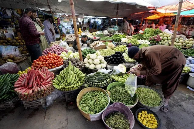 People visit a market to buy vegetables and other stuff, in Karachi, Pakistan, Tuesday, February 14, 2023. Cash-strapped Pakistan nearly doubled natural gas taxes Tuesday in an effort to comply with a long-stalled financial bailout, raising concerns about the hardship that could be passed on to consumers in the impoverished south Asian country. Pakistan's move came as the country struggles with instability stemming from an economic crisis. (Photo by Fareed Khan/AP Photo)