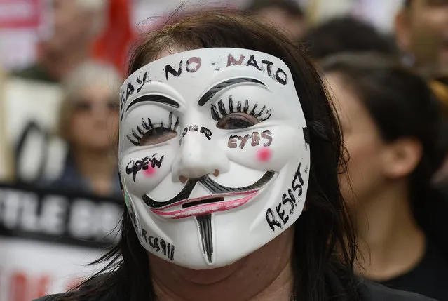 Wales: A demonstrator wearing a Guy Fawkes mask takes part in an anti-war protest march in Newport, Wales, August 30, 2014. (Photo by Rebecca Naden/Reuters)