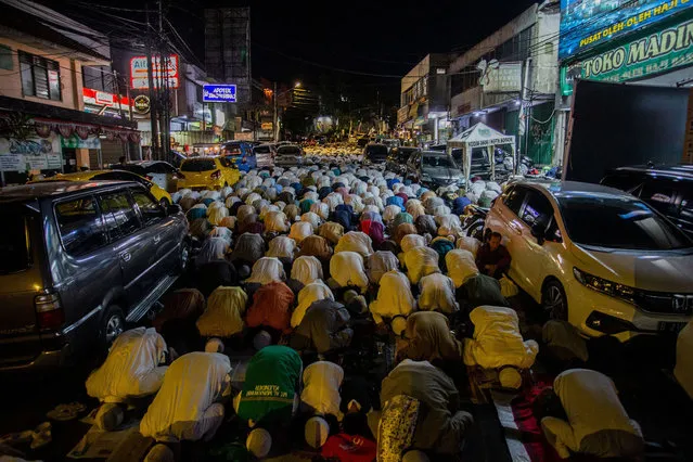 This picture taken on April 11, 2023 shows Muslims performing night prayers on a street during the holy month of Ramadan in Bogor in Indonesia's West Java province. (Photo by Aditya Aji/AFP Phoot)