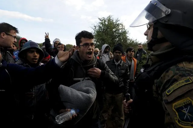 Stranded migrants argue with Macedonian police officers as they try to cross the Greek-Macedonian border, near the village of Idomeni, Greece  December 2, 2015. Picture taken from the Greek side of the border. (Photo by Alexandros Avramidis/Reuters)