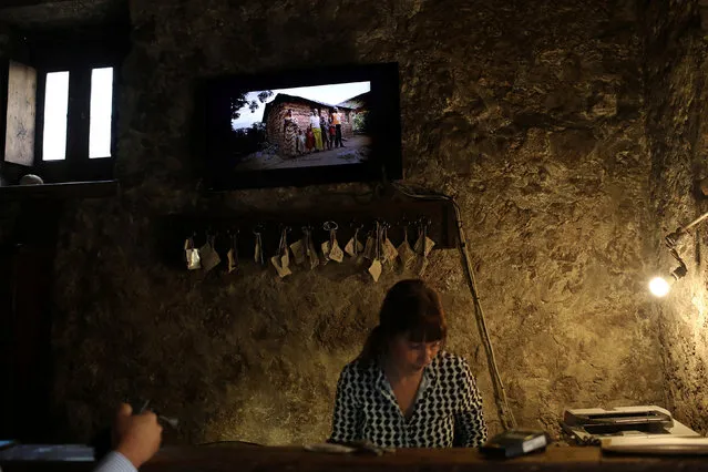 A receptionist assists a visitor at the front desk of the reception of Swedish-Italian entrepreneur Daniele Khilgren's Sextantio Albergo Diffuso, a hotel which has rooms throughout the town of Stefano di Sessanio in the province of L'Aquila in Abruzzo, inside the national park of the Gran Sasso e Monti della Laga, Italy, September 14, 2016. (Photo by Siegfried Modola/Reuters)