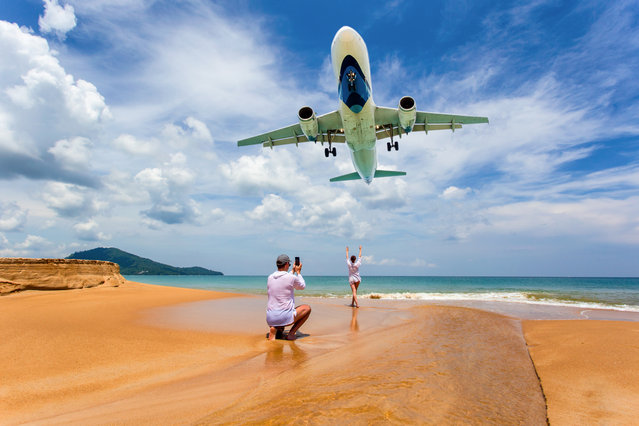 Portrait couple lover on the beach, Landing aircraft above the beach at Phuket Airport, Mai Khao beach, one of the most popular beaches among tourists in Phuket, Thailand, 2018. (Photo by Pakin Songmor/Getty Images)